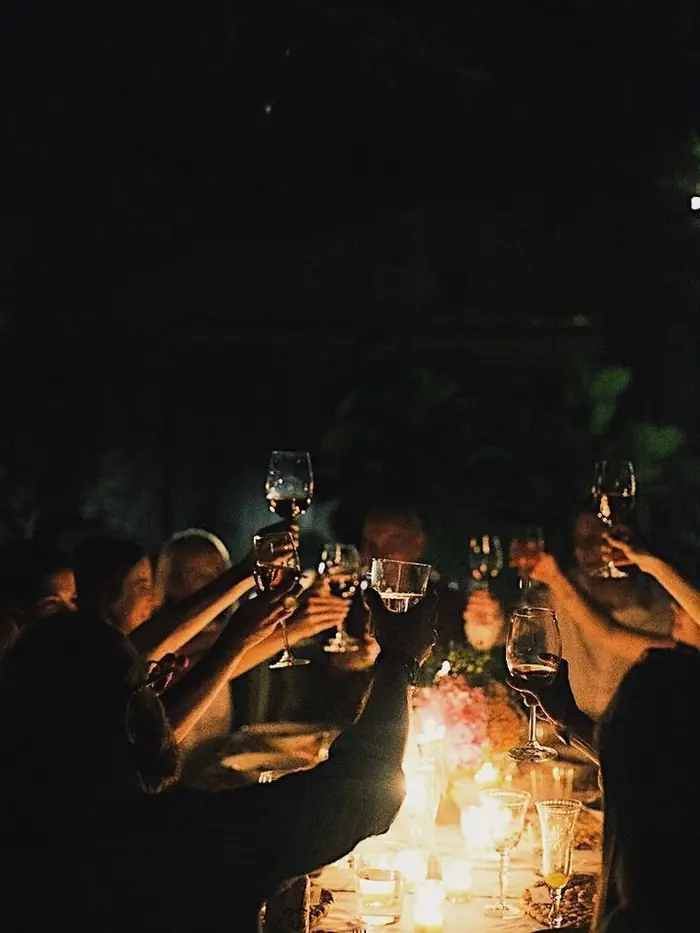 Guests around a candlelit table late in the evening